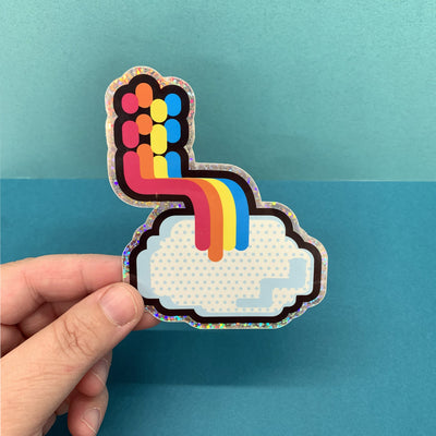 Hand holding Bent Rainbow sticker by Tomato Tomato on a blue background